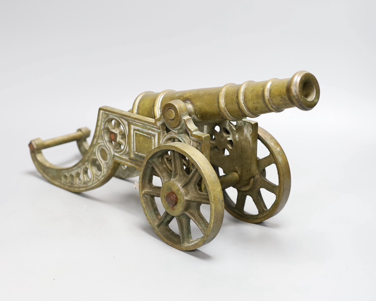 A cast bronze model of a cannon and a pair of cast brass sailors, cannon length 45cm